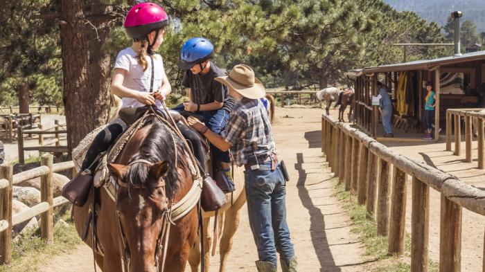 Zwei Kinder auf Pferden bekommen Reitunterricht beim Western Reiturlaub