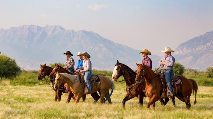 Reitergruppe auf Pferden Westernreiten durch die Prärie in Utah in den USA