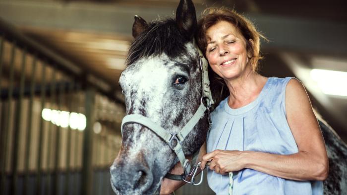 Reiten lernen für Erwachsene  - Reiterin schmust mit Pferd