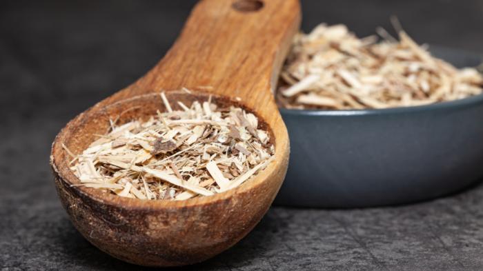 Ein Holzlöffel und eine Schale mit geraspelter Taigawurzel 