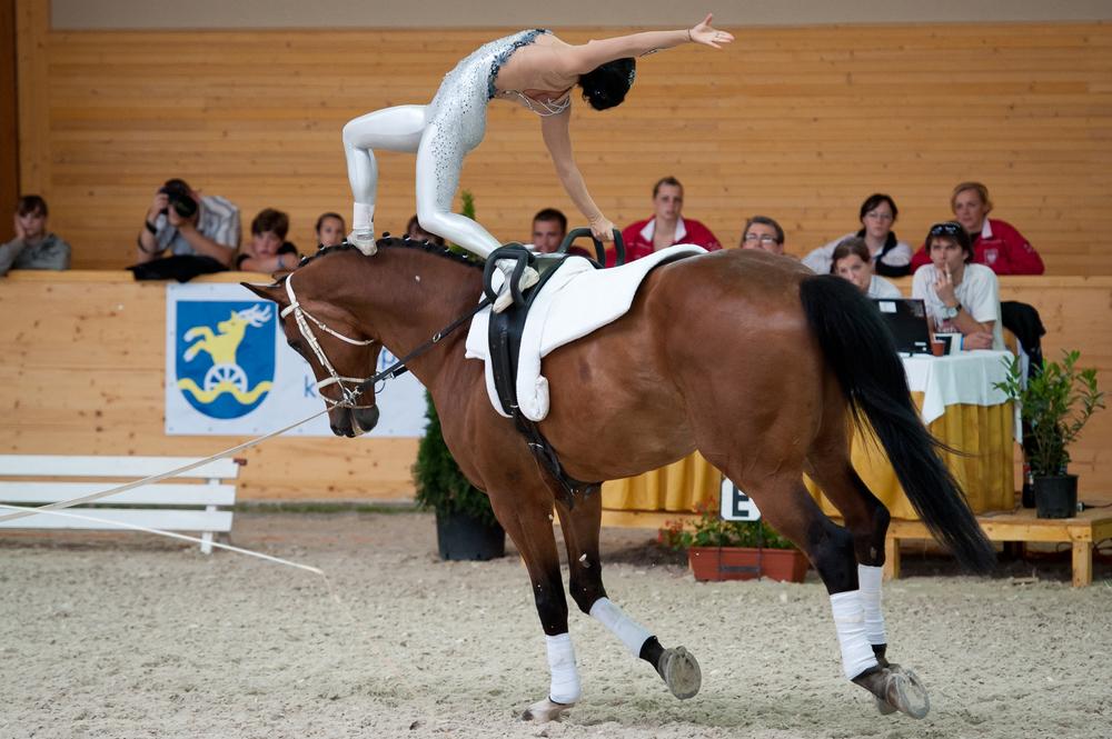 Reiterin zeigt eine akrobatischen Übung beim Voltigieren