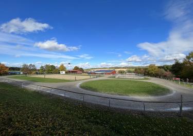 Große Ovalbahn mit Dressurviereck und Roundpen in der Mitte auf dem Islandpferdehof Söhrewald