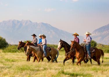 Reitergruppe auf Pferden Westernreiten durch die Prärie in Utah in den USA
